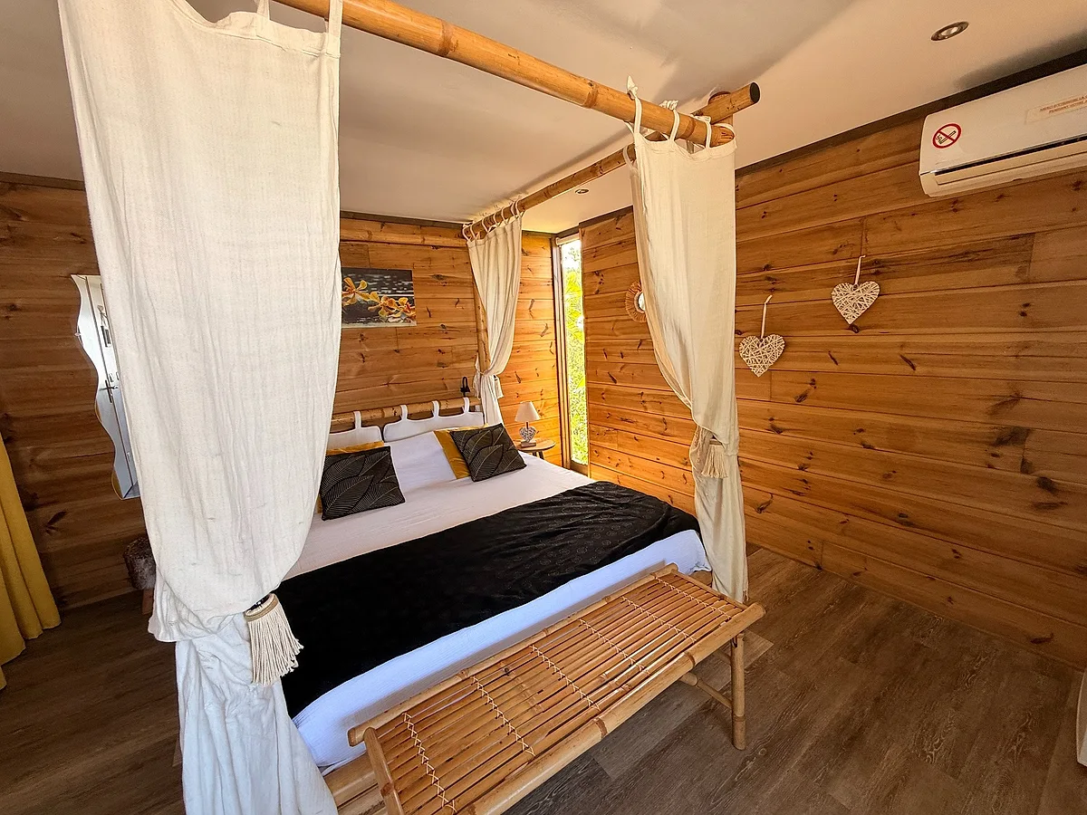 Le lit à baldaquin du bungalow Bananier, habillé de voilages blancs