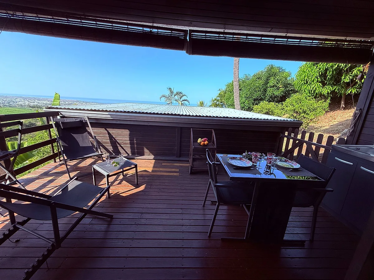 La terrasse d'un bungalow avec sa table, face à l'océan