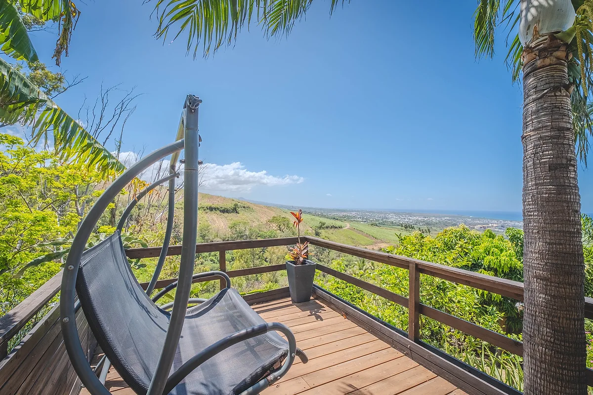 Un fauteuil suspendu sur la terrasse, avec la vue sur les cannes et l'océan