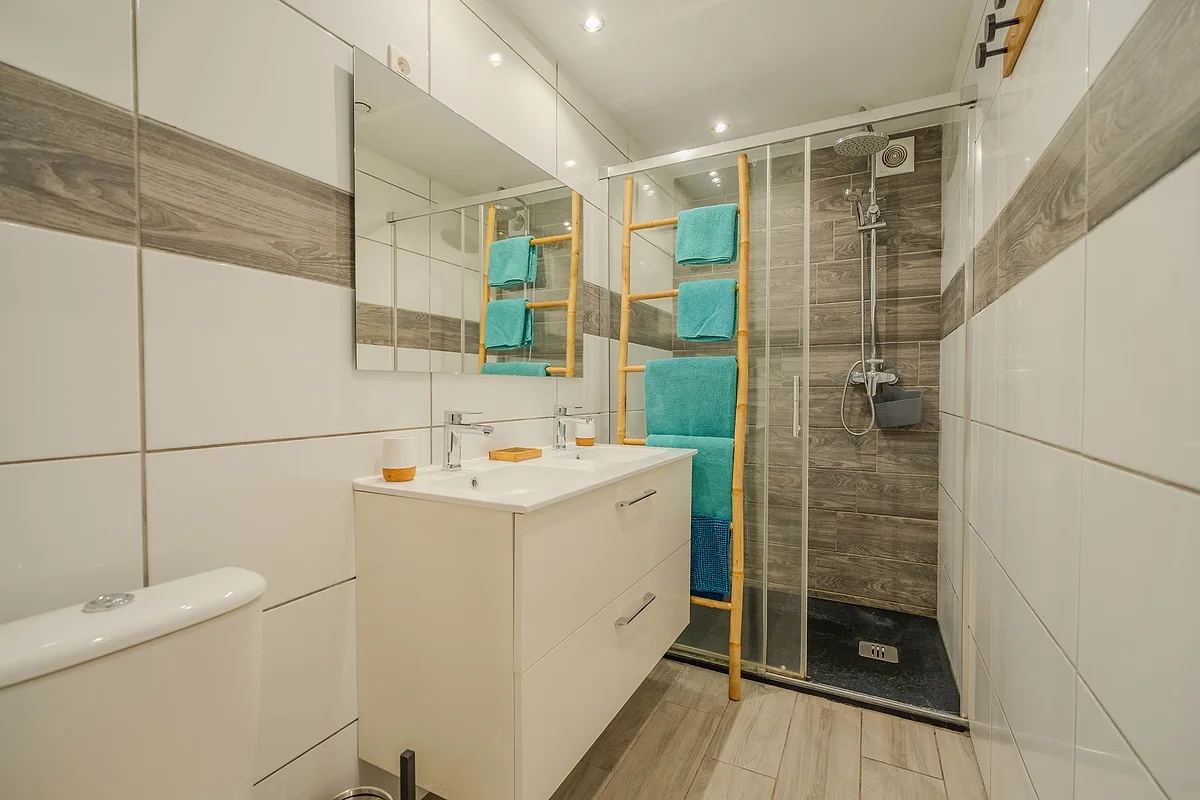 La salle d'eau du studio Le Jade, sa douche et sa double vasque