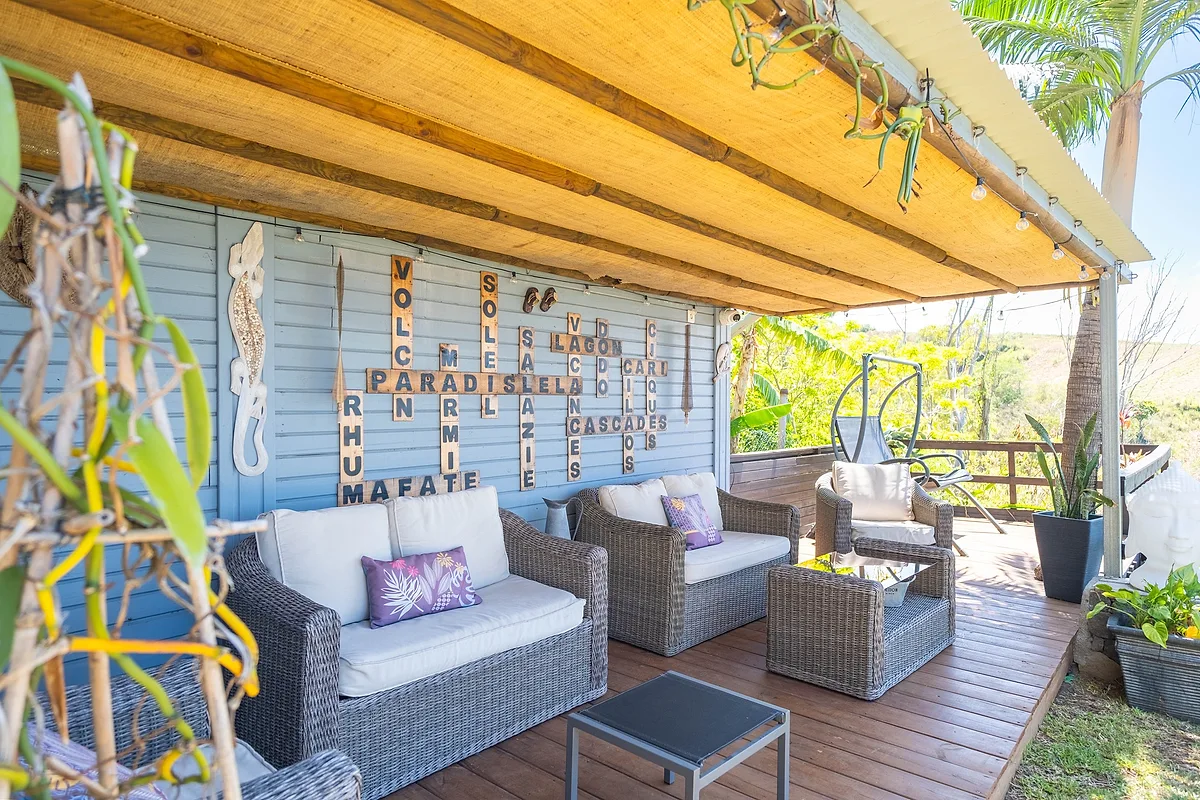 Le salon de jardin sous la varangue, ses fauteuils en rotin et ses coussins